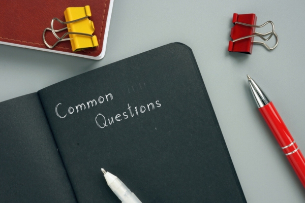 Common questions written on a notebook depicting FAQs about heat pumps & HSPF